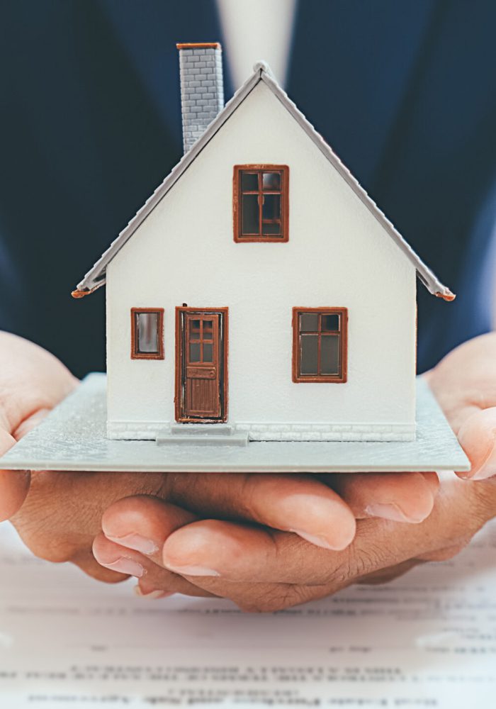 House model with real estate agent and customer discussing for c makler-mit-modellhaus